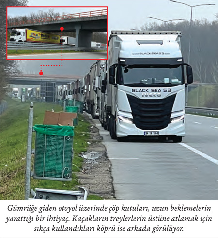 Gümrüğe giden otoyol üzerinde çöp kutuları, uzun beklemelerin yarattığı bir ihtiyaç. Kaçakların treylerlerin üstüne atlamak için sıkça kullandıkları köprü ise arkada görülüyor.